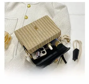 Vue intérieure du sac en paille avec fermoir doré montrant la capacité pour maquillage