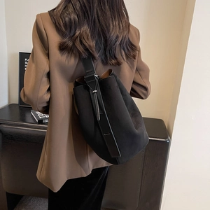 Sac seau minimaliste noir mat avec large bandoulière réglable et détails de boucle