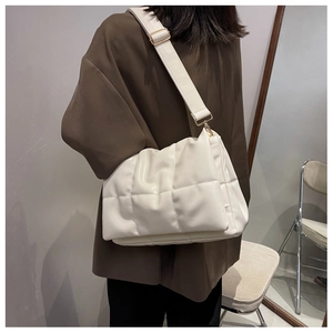 Détail du sac matelassé blanc cassé avec surpiqûres en losanges et large bandoulière
