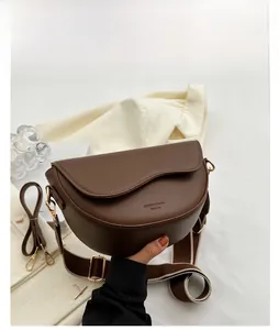 Detail of coffee brown crescent crossbody bag with wide canvas strap and matte finish