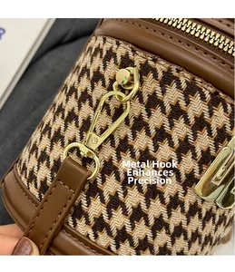 Close-up of gold metal hook and brown houndstooth fabric on the designer bucket bag