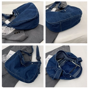 Minimalist dark blue washed denim messenger bag with wide strap and metallic zipper closure