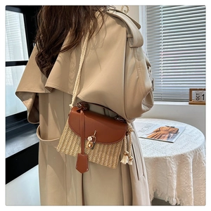 Sac en paille avec rabat en cuir et breloque fleur dans un décor de style de vie