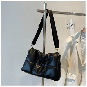 Détail du sac bandoulière matelassé noir avec coutures en losange et boucle dorée chic