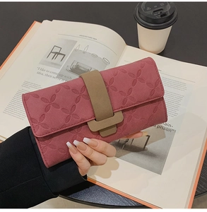 Vue rapprochée du long portefeuille rose avec gaufrage floral et boucle marron