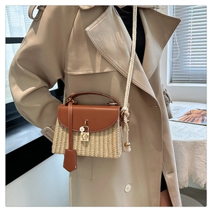 Détail du sac bandoulière en paille avec rabat en cuir brun et sangle en coton