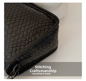 Detail of black woven leather texture with precise stitching and metallic buckle