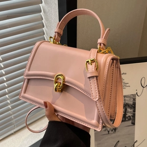 Elegant pink crossbody bag with gold metal lock and handle for versatile styling