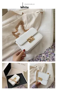 Detail of white crocodile embossed mini bag featuring gold chain and metallic lock clasp