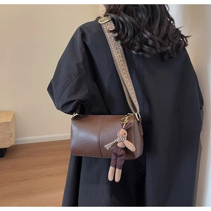 Sac cylindre marron avec bandoulière ethnique et détail de charm lapin en peluche