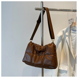 Détail d'un sac à bandoulière matelassé marron foncé en similicuir avec sangle réglable
