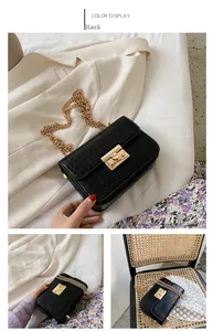 Detail of black crocodile texture bag with gold lock and stylish chain strap