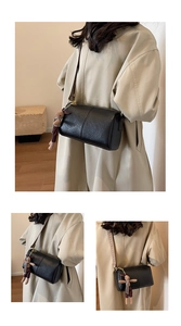 Black leather cylinder bag with jacquard strap and plush bunny charm detail