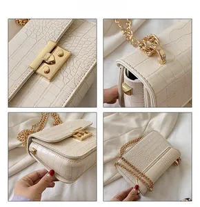 Detail of crocodile pattern texture, gold lock and chain on cream small square bag