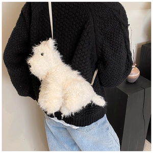 Détail d'un sac bandoulière en peluche chien blanc sur un mannequin en pull noir