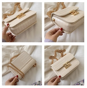 Detail showing crocodile texture cream crossbody bag with gold chain and push-lock