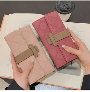 Détail de portefeuilles en cuir gaufré floral rose avec fermeture à bouton-pression