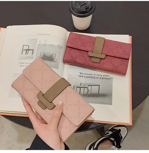Détails du motif trèfle embossé sur des portefeuilles longs en similicuir rose et bordeaux