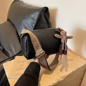 Sac cylindrique noir minimaliste avec large bandoulière géométrique et breloque lapin