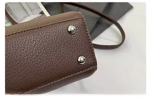 Details der Unterseite der braunen Lederhandtasche mit schützenden silbernen Metallfüßen