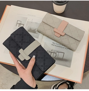 Détail du portefeuille long à gaufrage croisé et boucle en T en noir et crème