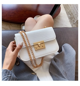 Detail of white crocodile pattern shoulder bag with gold chain and metal lock buckle