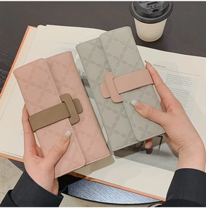 Détail de portefeuilles longs en cuir rose et vert sauge avec motif floral embossé