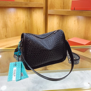 Woven black leather crossbody bag with geometric grid texture and patterned strap