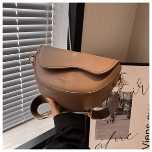 Detail of vintage camel saddle bag with textured leather and wide jacquard strap