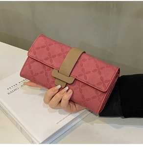 Détail du motif floral gaufré rouge rose sur le long portefeuille femme avec boucle