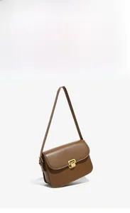 Detail view of brown vintage leather crossbody bag with square gold buckle and adjustable strap