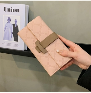 Détail du portefeuille long en cuir rose avec motif trèfle gaufré et boucle