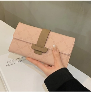Détail du portefeuille long en cuir gaufré rose clair avec boucle de fermeture marron
