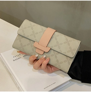 Détail de la pochette en cuir gris avec motif trèfle embossé et fermoir rose