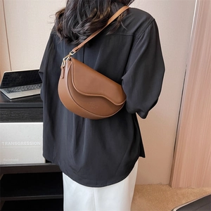 Retro brown leather saddle bag with adjustable shoulder strap shown on a model