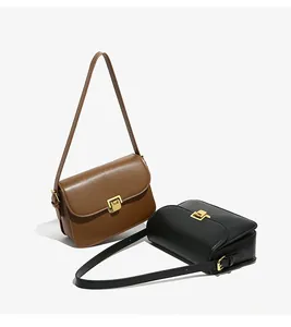 Detail of classic leather shoulder bags in brown and black with gold metal buckles