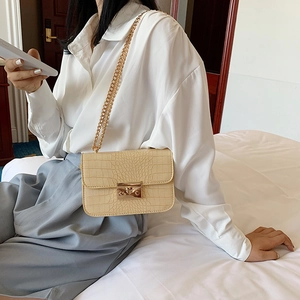 Elegant cream crocodile pattern crossbody bag with gold chain strap and metal clasp