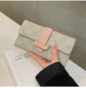 Détail du portefeuille long gris clair avec motifs floraux et boucle rose