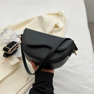 Minimalist black crescent crossbody bag with wave flap and wide woven strap