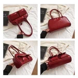 Detail view of deep red glossy PU leather Boston bag with dual pockets and handles