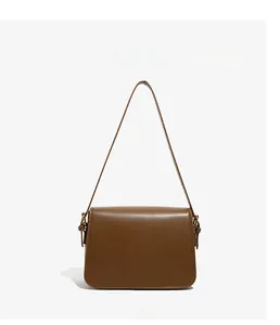 Detailed side view of dark caramel brown leather shoulder bag with vintage bronze buckle