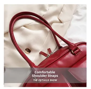 Detail view of red glossy leather shoulder bag with sleek dual zippers and sturdy straps