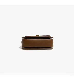 Detail view of the brown leather bag base with golden hardware and premium stitching