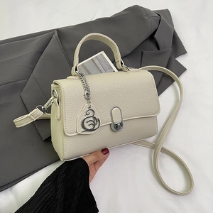 Beige Lederhandtasche mit Litschi-Muster, silbernem Schwanenanhänger und Tragegriff