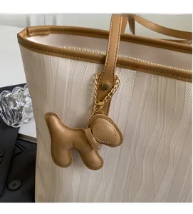 Detail of off-white wave texture tote bag with brown leather trim and puppy charm