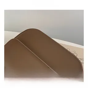 Gros plan détaillé sur la texture du cuir marron foncé et les coutures d'un petit sac