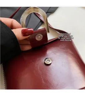 Detail of burgundy leather bucket bag featuring a hidden magnetic closure for easy access