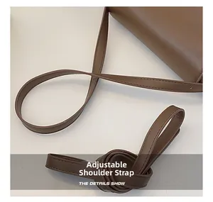 Vue détaillée de la bandoulière réglable en cuir sur un sac à bandoulière marron