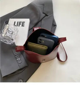 Interior view of wine red bucket bag showing space for two phones and a small wallet