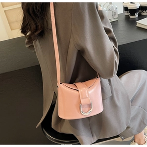 Detail of pink leather bucket bag with silver U-shaped buckle and long shoulder strap